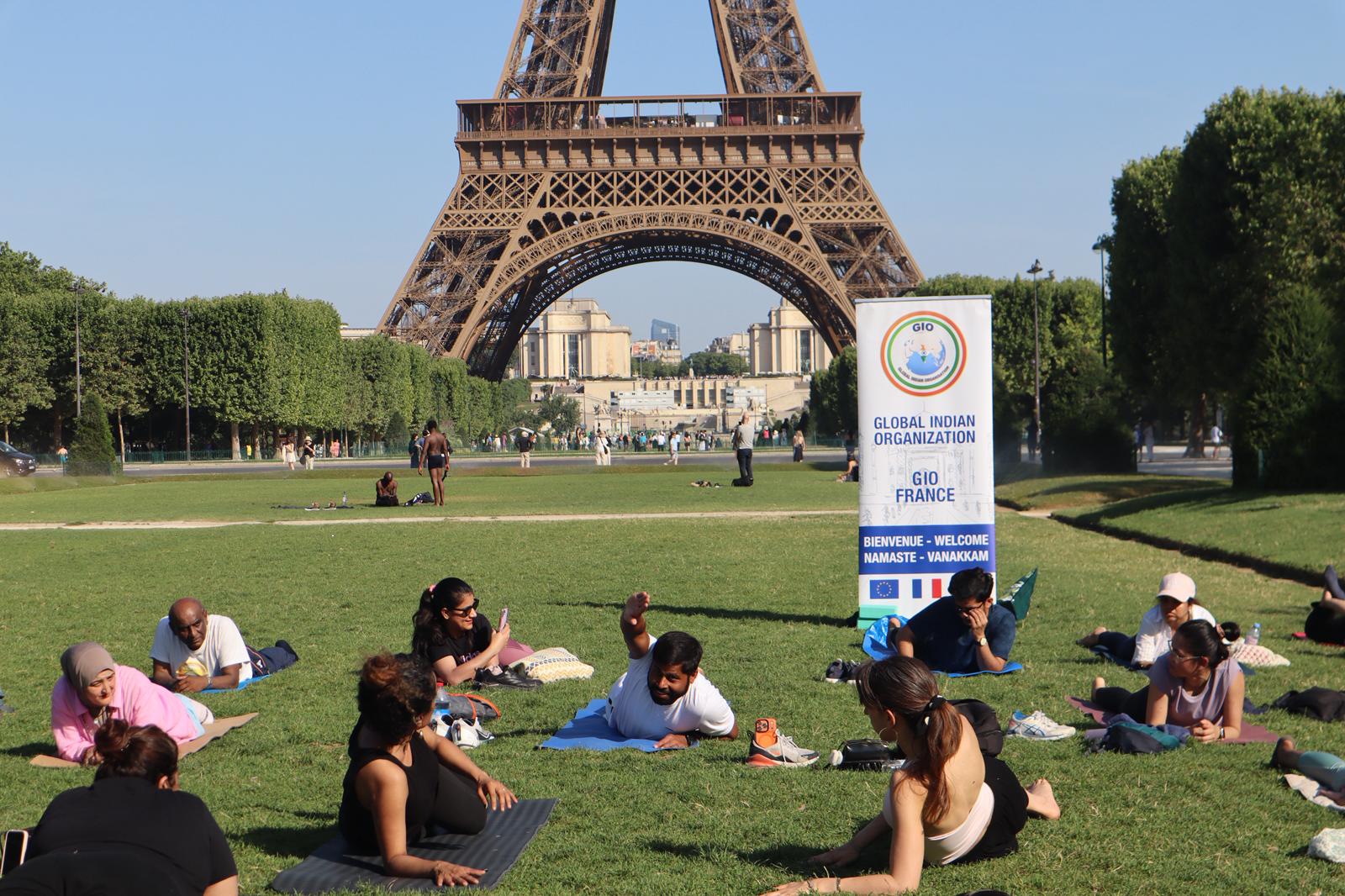 Séance de Hatha Yoga au Champ-de-Mars, Tour Eiffel en arrière-plan, bannière GIO France