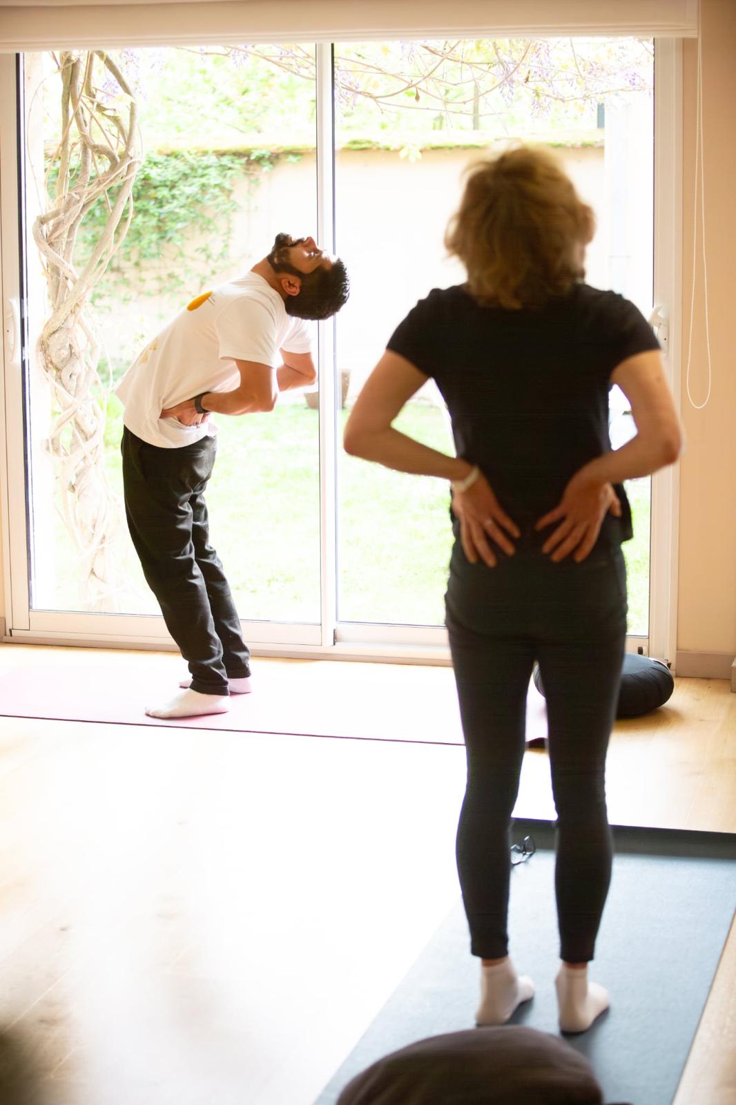 Jitendra guide un élève dans une posture d'ouverture du dos